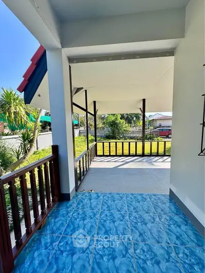 Charming outdoor patio with vibrant blue tiles and lush garden view, perfect for relaxation and entertaining.