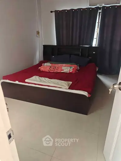 Cozy bedroom with dark curtains and modern bed frame, perfect for restful nights.