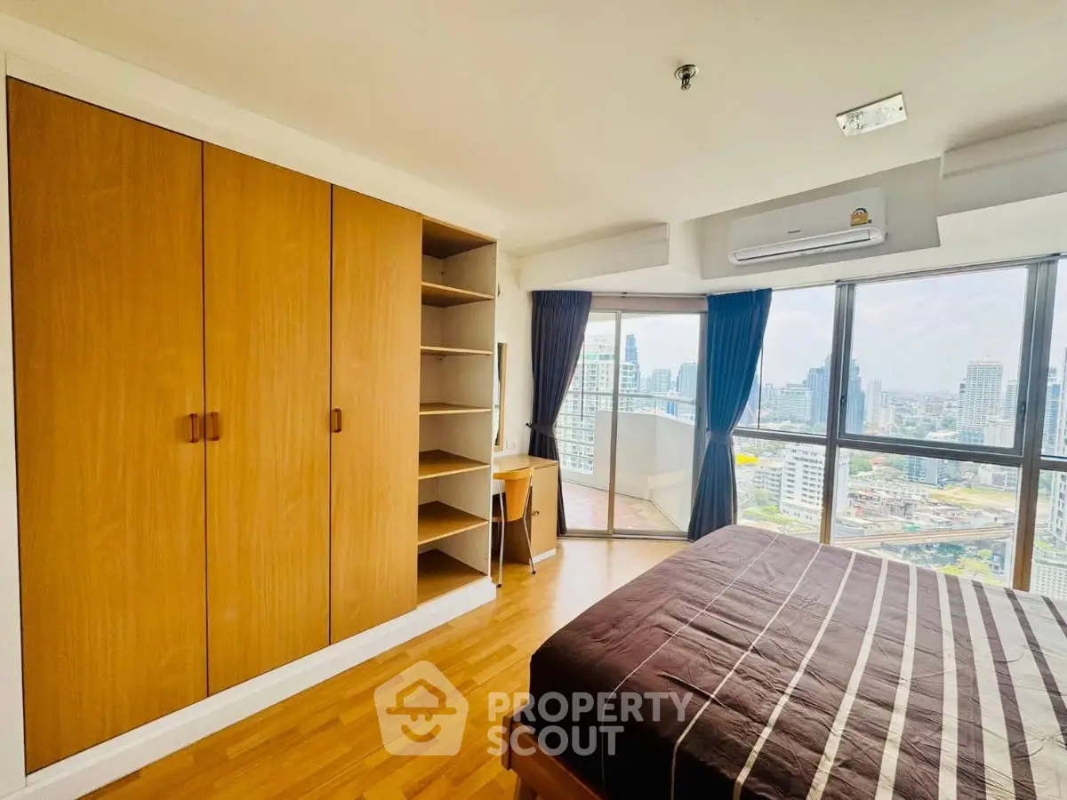 Spacious bedroom with city view and ample storage in modern apartment