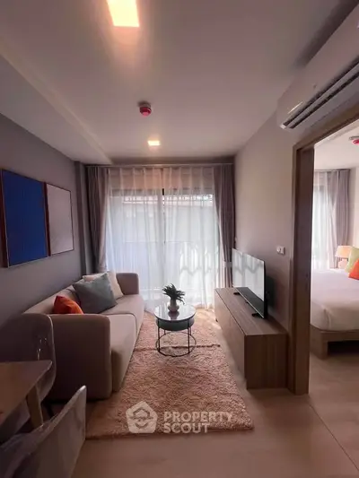 Modern living room with cozy decor and natural light, featuring a comfortable sofa and stylish furnishings.