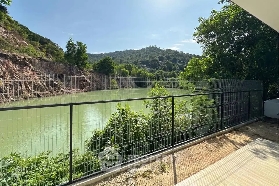 Stunning river view from a private balcony with lush greenery and serene surroundings.