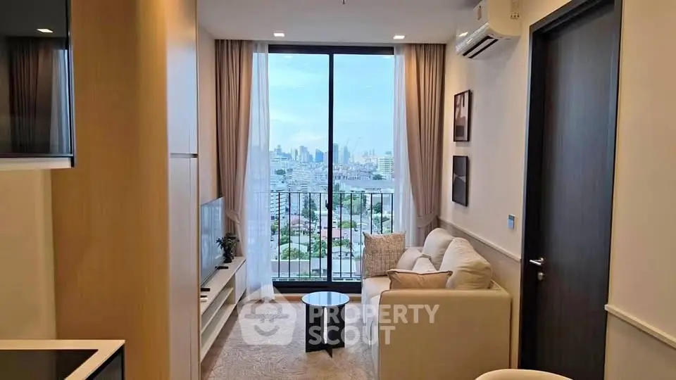 Modern living room with city view, featuring cozy sofa and large window for natural light.