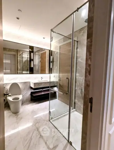 Luxurious modern bathroom with glass shower and marble finishes