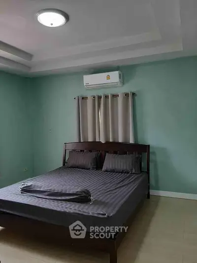 Spacious bedroom with modern bed and air conditioning in a serene setting.