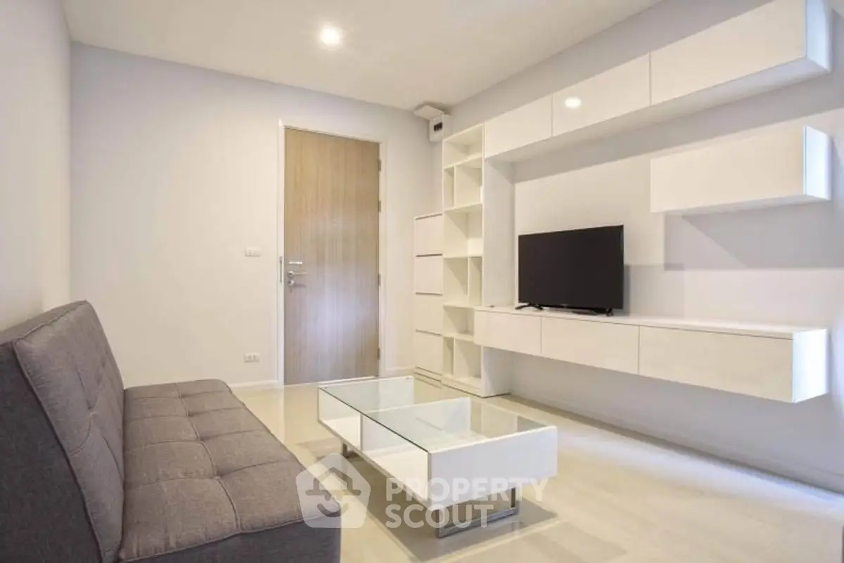 Modern living room with sleek furniture and wall-mounted TV in a minimalist design.