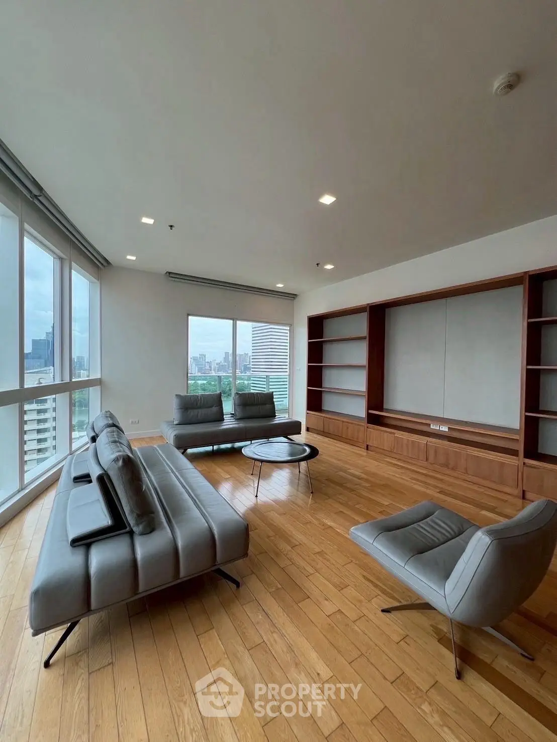 Spacious modern living room with panoramic city views and stylish furniture.