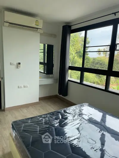 Bright bedroom with large windows and air conditioning in modern apartment