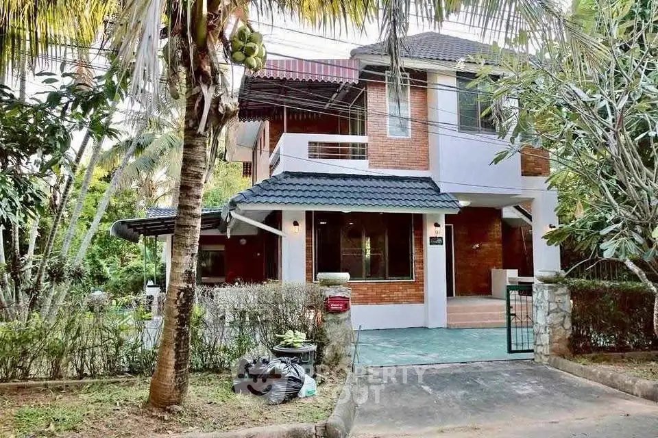 Charming two-story house with lush garden and inviting entrance in a serene neighborhood.
