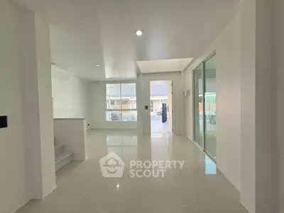 Spacious modern living area with glossy tiled floors and ample natural light