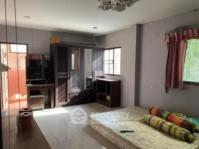 Spacious bedroom with natural light, featuring a mattress, wardrobe, and desk, ideal for customization.