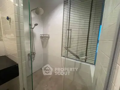 Modern bathroom with glass shower enclosure and sleek fixtures.