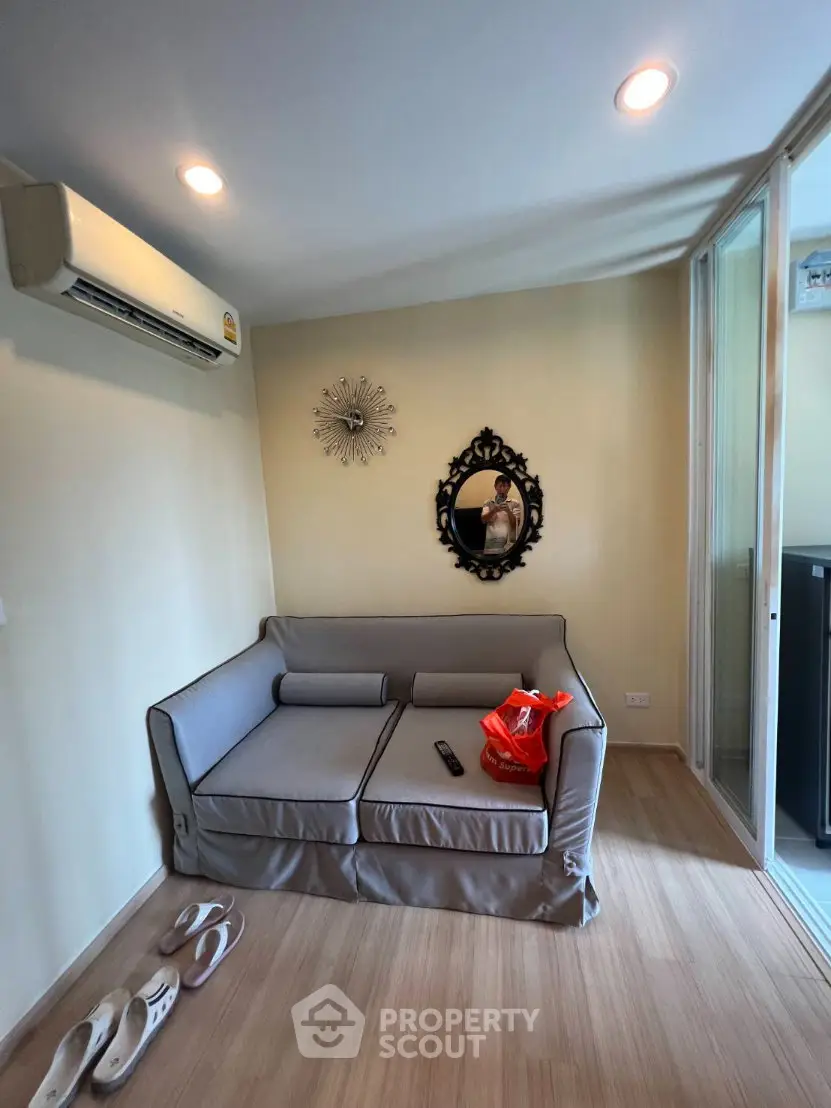Cozy living room with modern sofa and air conditioning, perfect for relaxation.