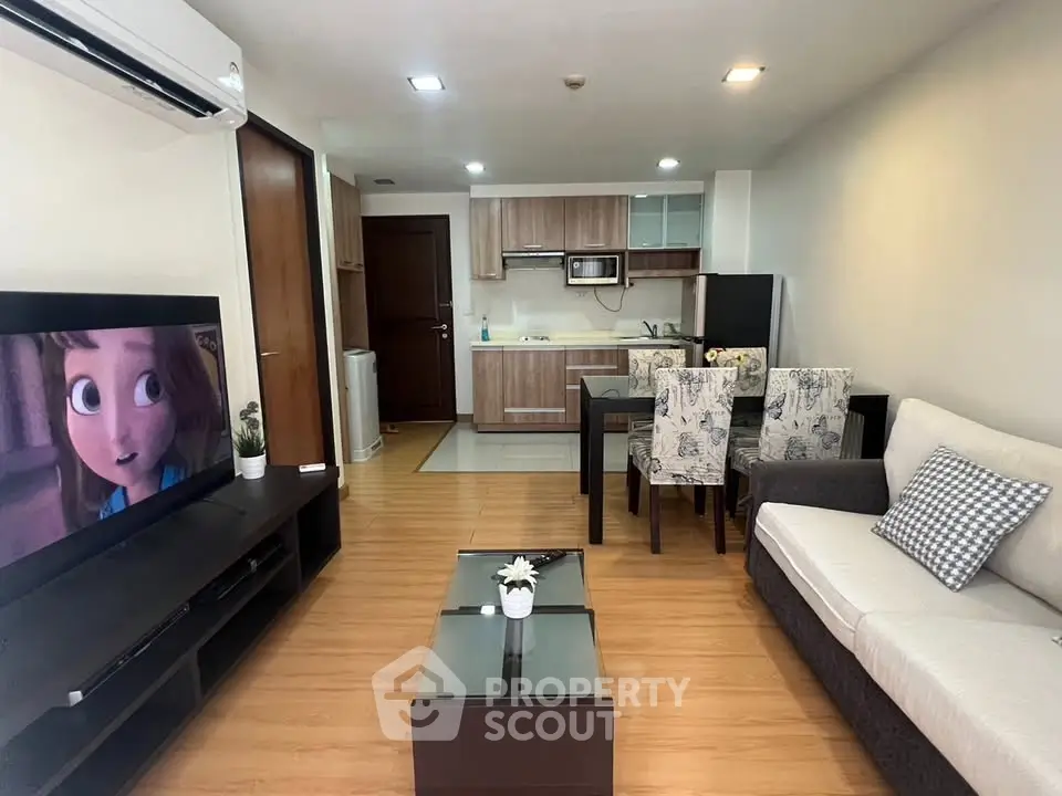 Modern living room with open kitchen, cozy seating, and stylish decor in a contemporary apartment.