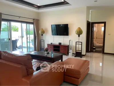 Spacious living room with modern decor and pool view, perfect for relaxation and entertainment.