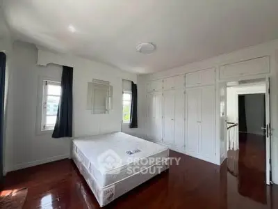 Spacious bedroom with hardwood floors and built-in wardrobes, perfect for comfort and storage.