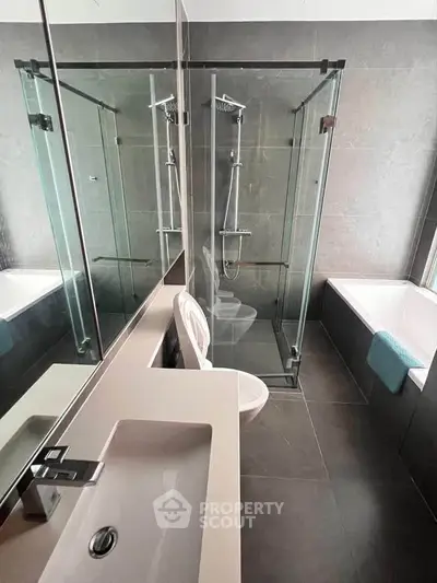 Modern bathroom with glass shower and bathtub in luxury apartment