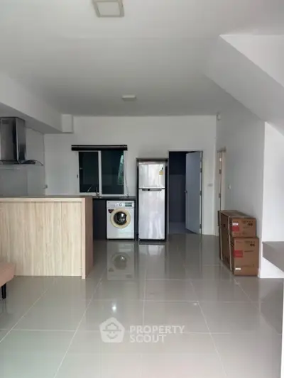 Modern kitchen with washing machine and fridge in open layout