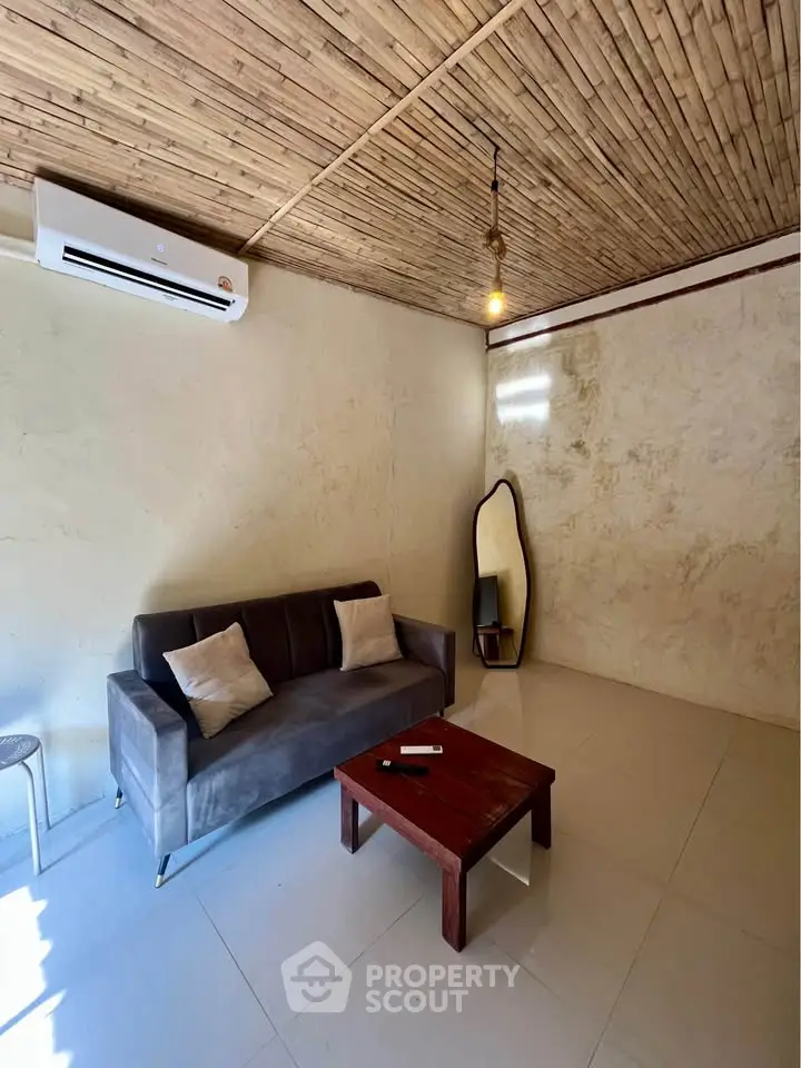Cozy living room with rustic ceiling, modern sofa, and stylish mirror for a warm ambiance.