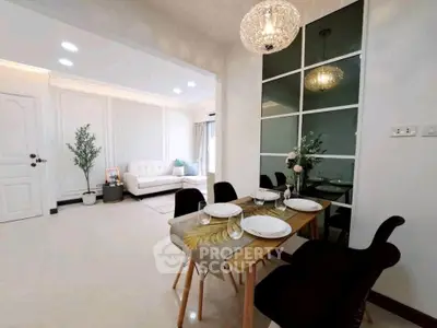 Elegant dining area with modern decor and cozy living room in open layout apartment.