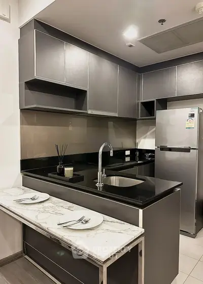 Modern kitchen with sleek cabinetry and stainless steel appliances in a stylish apartment.