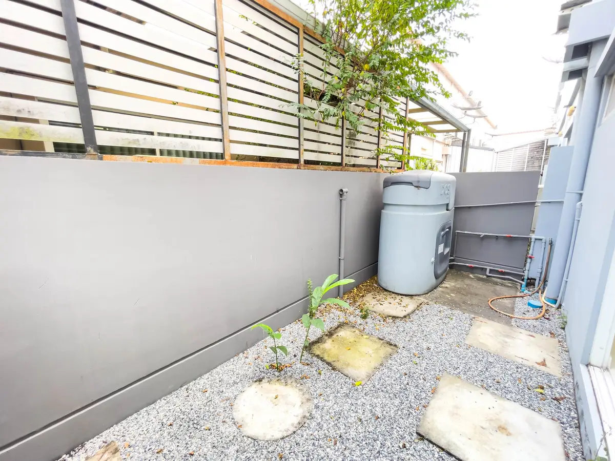Charming outdoor space with gravel path and privacy fence, perfect for urban gardening or relaxation.