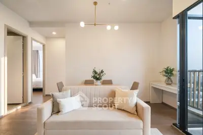 Elegant living room with modern decor and balcony view, featuring a cozy sofa and stylish lighting.