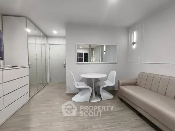 Modern minimalist living room with sleek furniture and mirrored storage