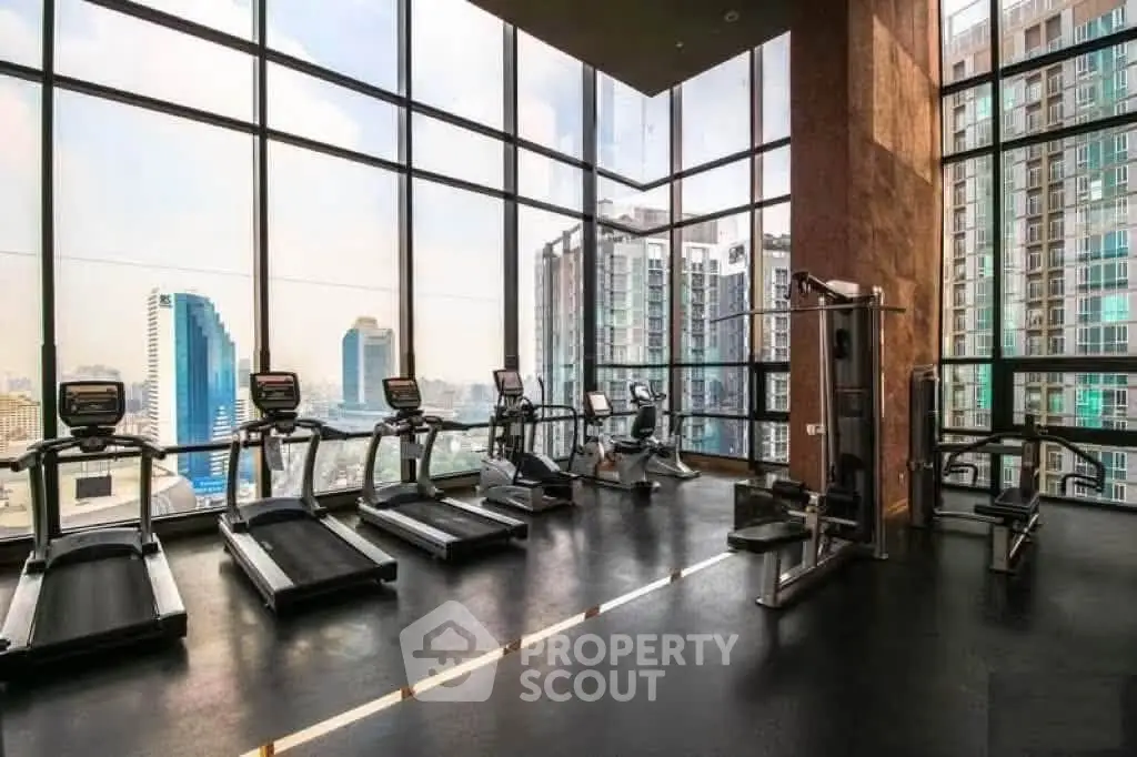 Luxurious high-rise gym with panoramic city views and modern fitness equipment.