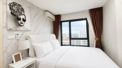Modern bedroom with stylish decor and city view, featuring a comfortable bed and elegant furnishings.