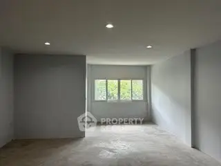 Spacious empty room with large windows and natural light, ideal for customization.