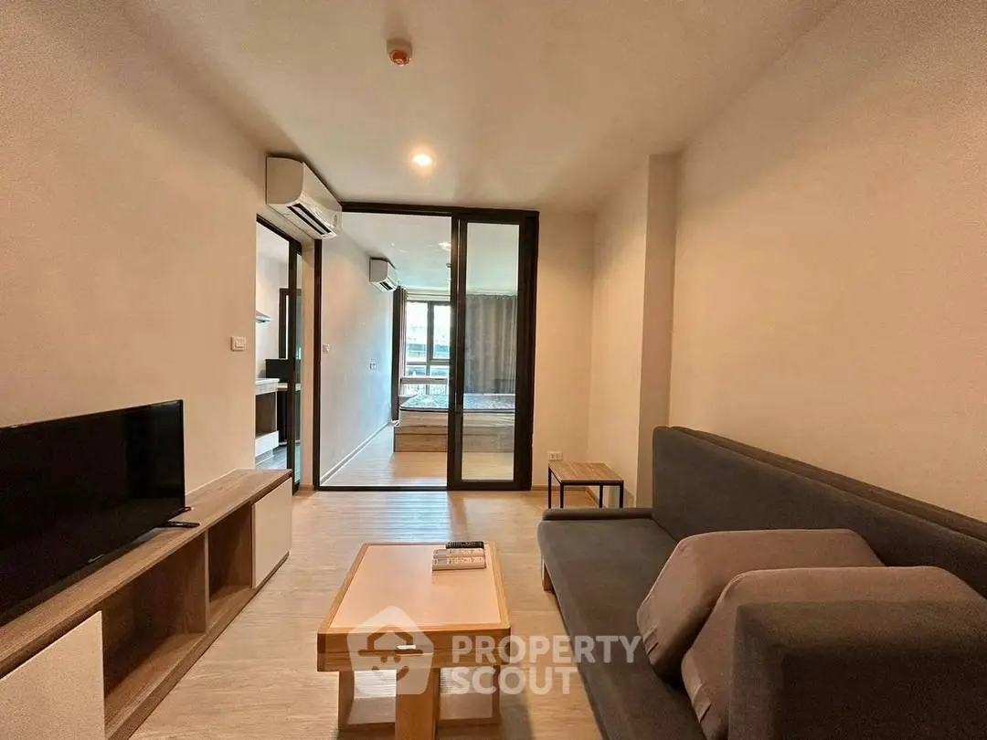 Modern living room with sleek furniture and glass partition in a stylish apartment.