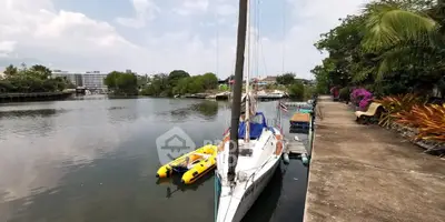 Scenic waterfront view with boats and lush greenery, perfect for tranquil living.