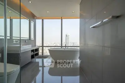 Luxurious bathroom with city view and freestanding bathtub in modern high-rise apartment.