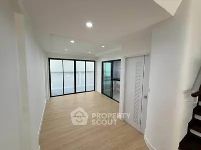 Spacious modern living room with large windows and wooden flooring