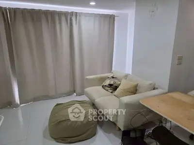 Cozy living room with modern sofa and bean bag, perfect for relaxation.