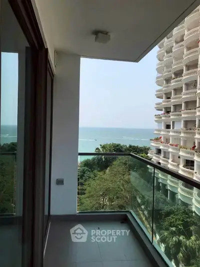 Stunning balcony with glass railing offering breathtaking ocean view in modern high-rise building.
