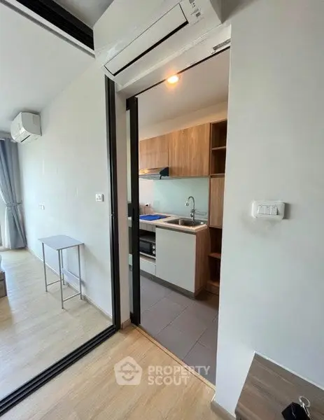 Modern apartment with open kitchen and sleek design, featuring air conditioning and natural light.