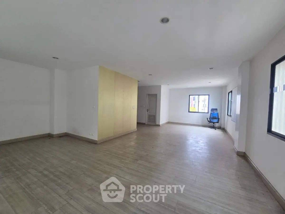 Spacious open-plan living area with large windows and modern flooring, ideal for customization.