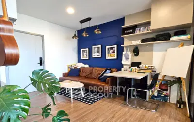 Stylish living room with modern decor, leather sofa, and vibrant blue accent wall.