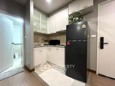 Modern kitchen with sleek cabinets and stainless steel fridge in cozy apartment
