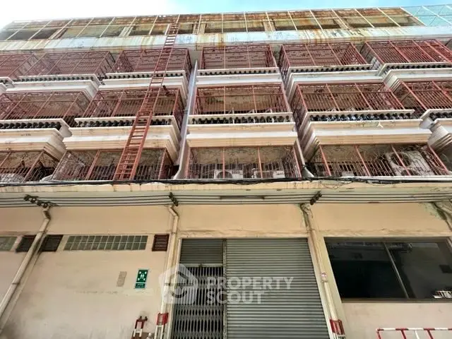 Commercial building exterior with multiple balconies and secure gated entrances.