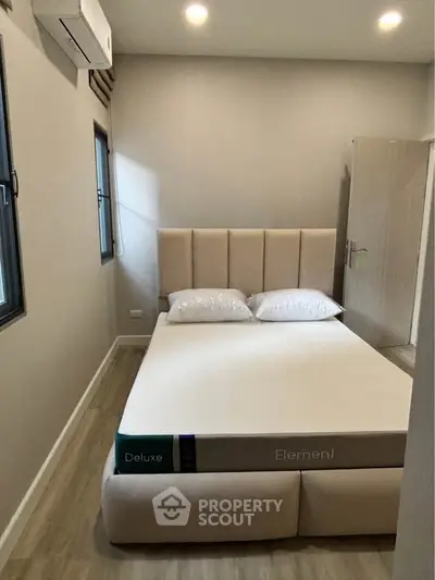 Modern bedroom with minimalist design and cozy atmosphere, featuring a comfortable bed and natural light.