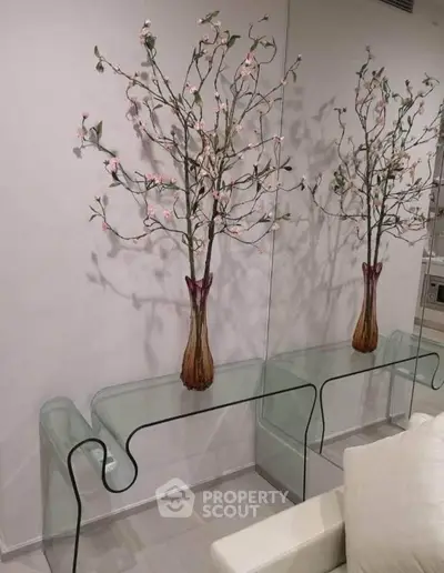 Elegant interior with glass console table and decorative floral arrangement, enhancing modern living space.