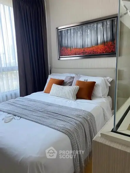 Cozy bedroom with stylish decor and large window offering natural light