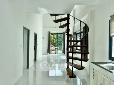 Modern interior with spiral staircase and large windows offering natural light and garden view.