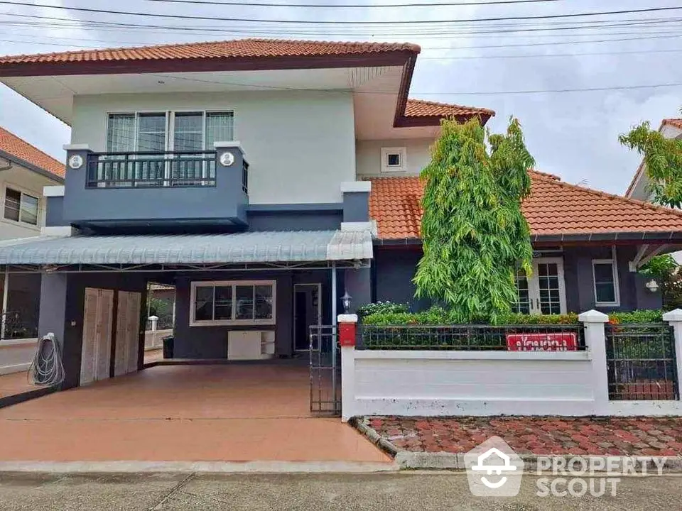 Charming two-story house with red-tiled roof and spacious driveway in serene neighborhood.