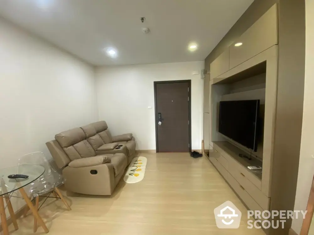 Modern living room with beige recliner sofa and wall-mounted TV unit