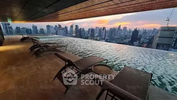 Luxurious rooftop infinity pool with stunning city skyline view at sunset.