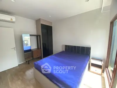 Bright and modern bedroom with large window and stylish furnishings