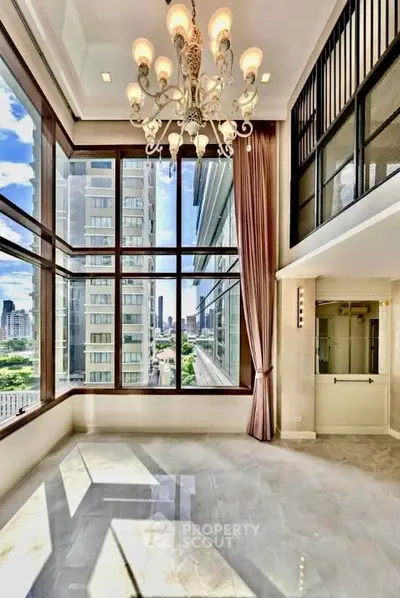 Luxurious high-rise apartment with stunning city views and elegant chandelier lighting.
